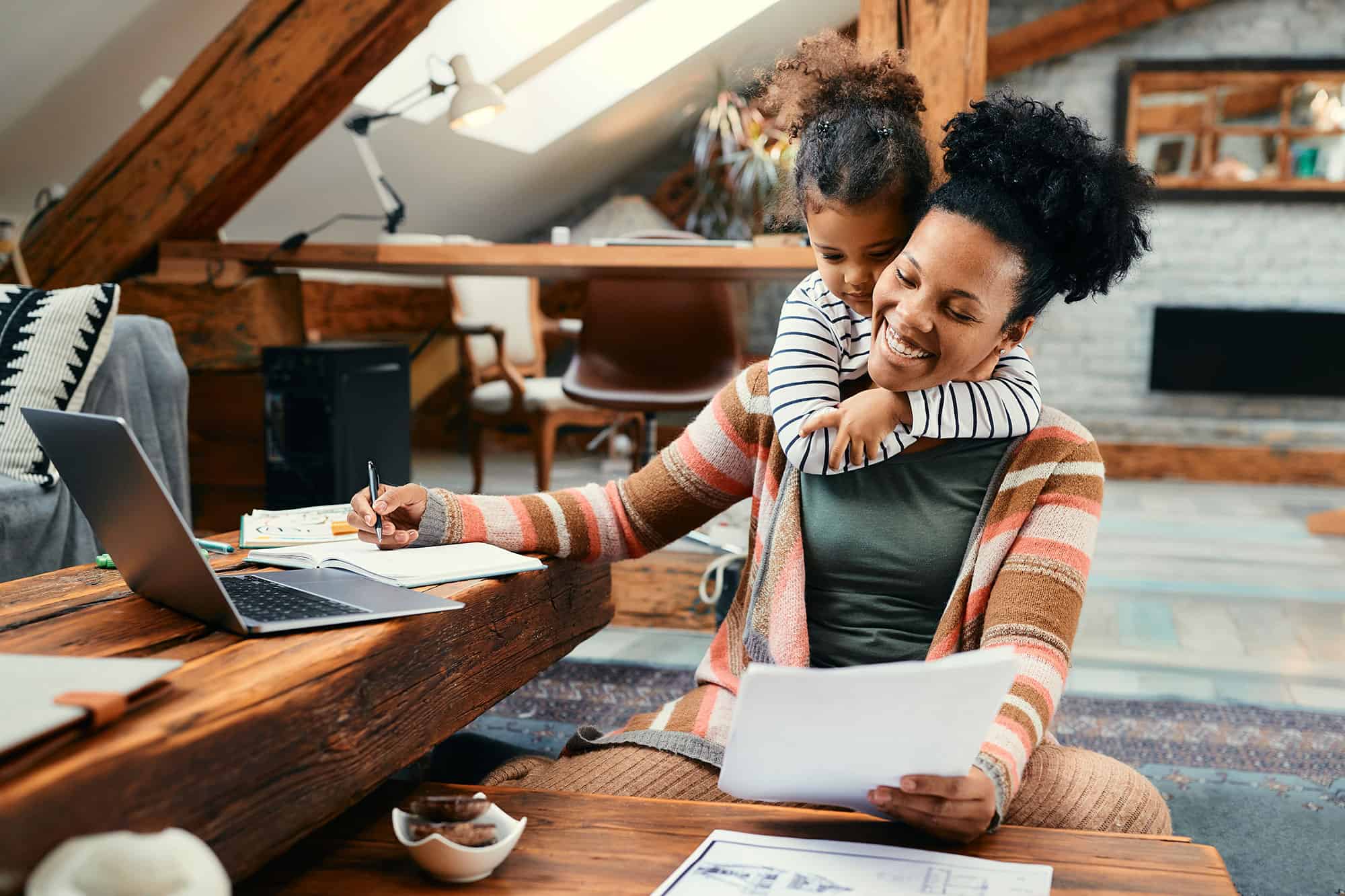 Happy African American mother working on paperwork with her daughter